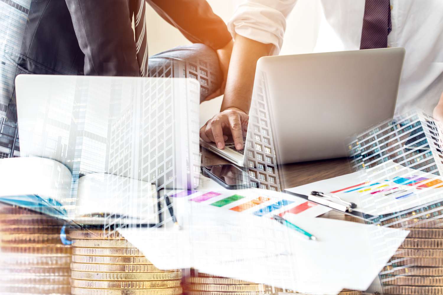 Financial Managers talking in front of laptops on a wooden table. on