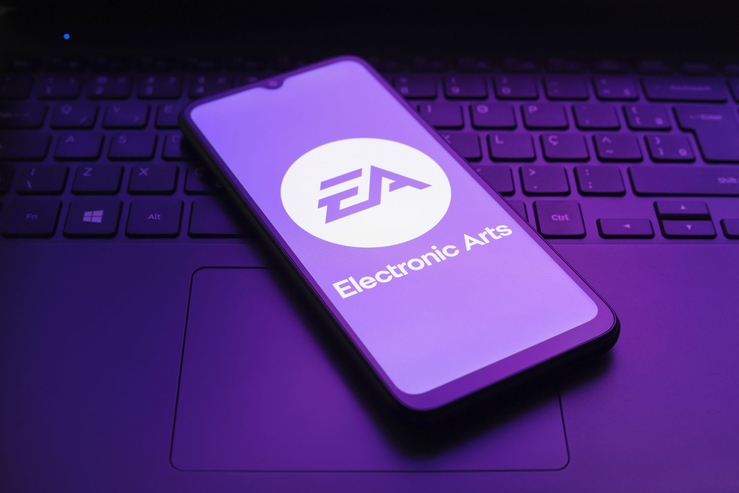 The Electronic Arts logo on a smartphone screen on top of a computer keyboard
