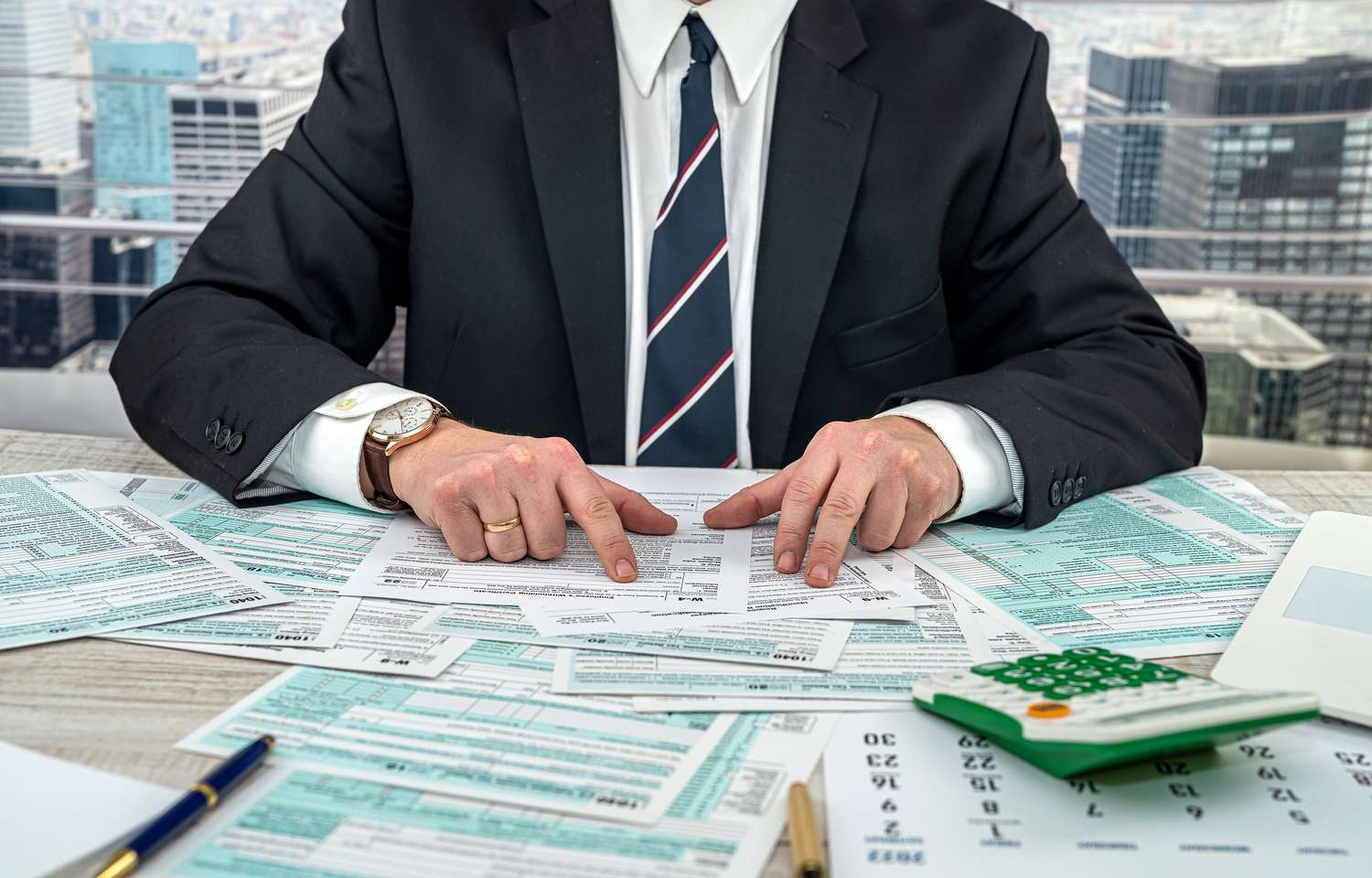 Businessman making calculation financial annual report and after fill 1040 tax form. 