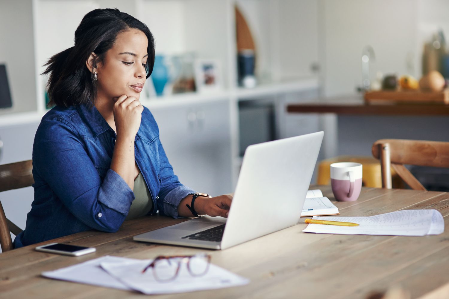 Young woman using laptop to research for her mortgage hardship letter 