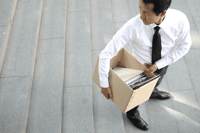 A man with his office supplies in a box