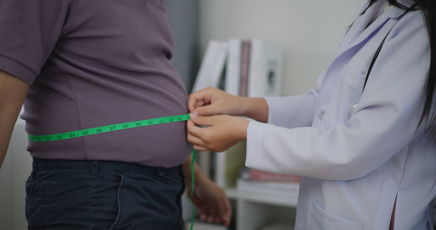 Doctor measuring a patient's waist size