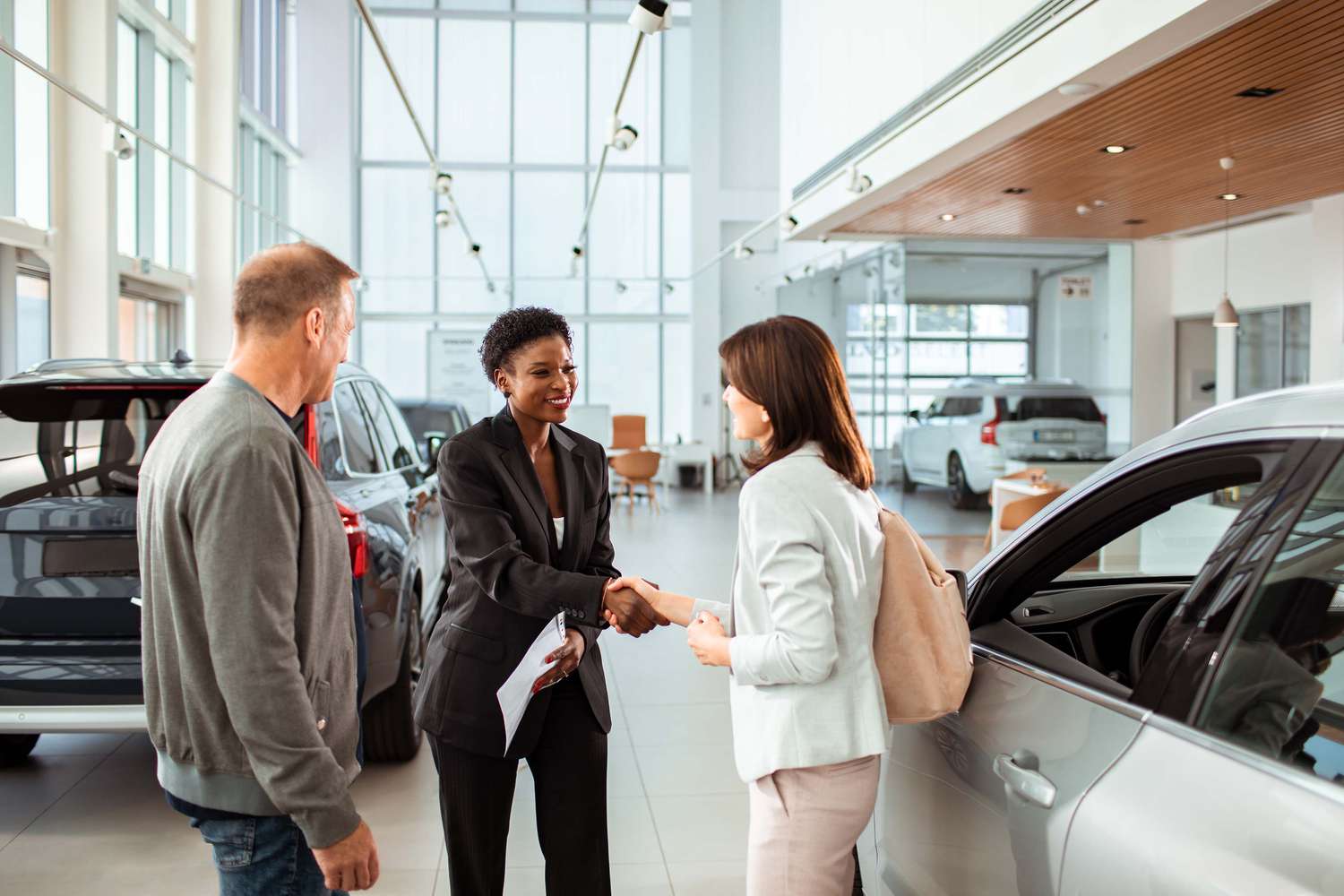 Couple picking up their new car at the dealership