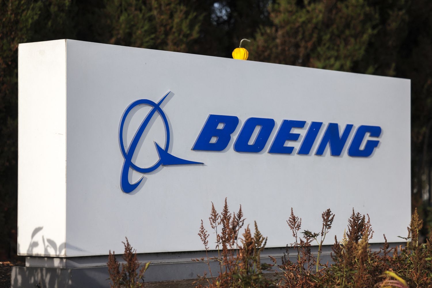 The blue Boeing logo is seen on a white sign.