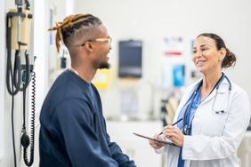 Patient talking with doctor about the procedures covered by health insurance premiums.