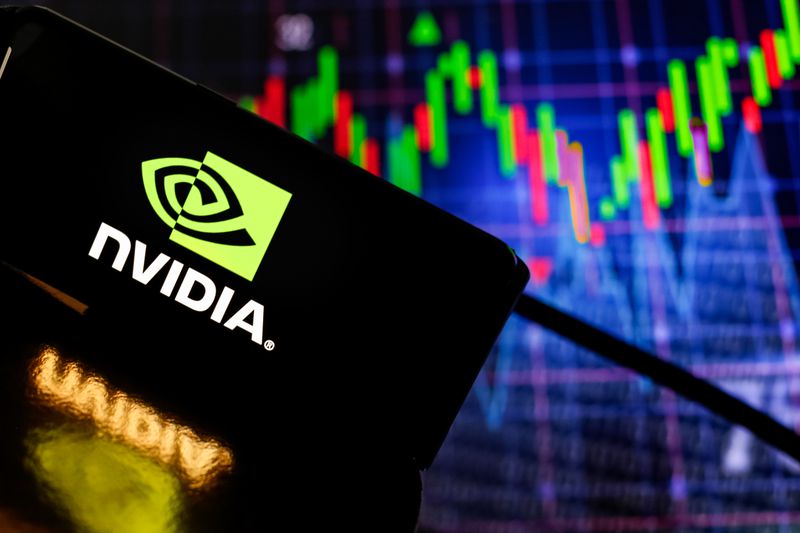 The Nvidia logo is displayed on a smartphone screen against a computer screen that displays stock graphs on August 19, 2024 