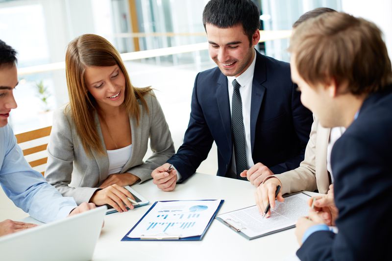 Business people gathered around charts at a meeting