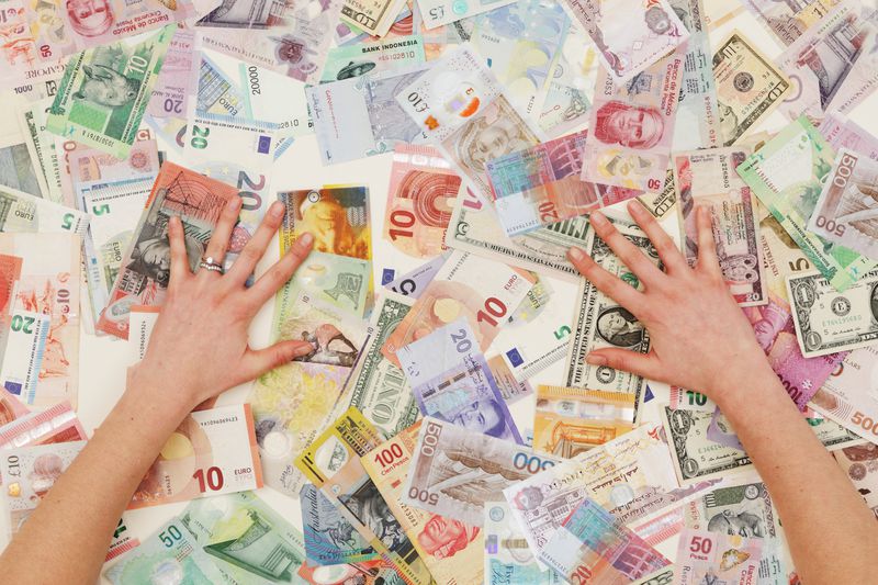 two hands on a pile of foreign currency