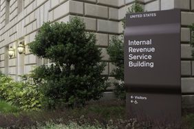 A directional sign sits in a planting bed and shows the direction for visitors to enter the United States Internal Revenue Service building.