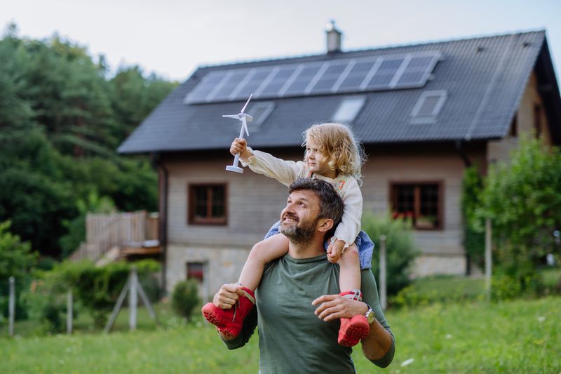 Father and child in front of home