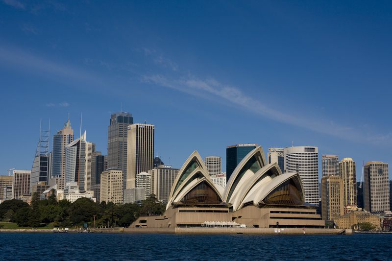 The iconic shells of the Sydney Opera House with the tall buildings of downtown Sydney in the background