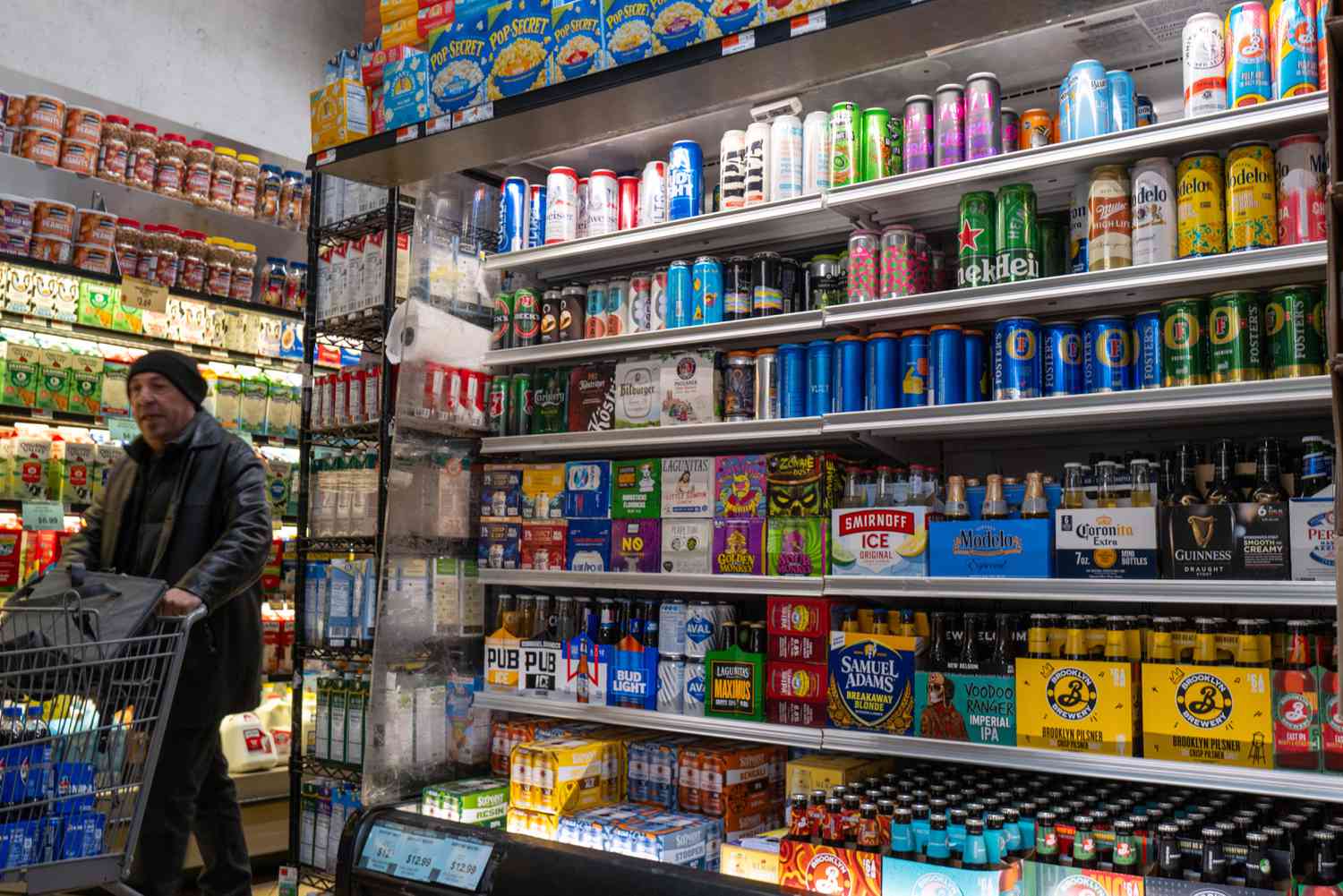 Beer sits in a fridge at a supermarket. 