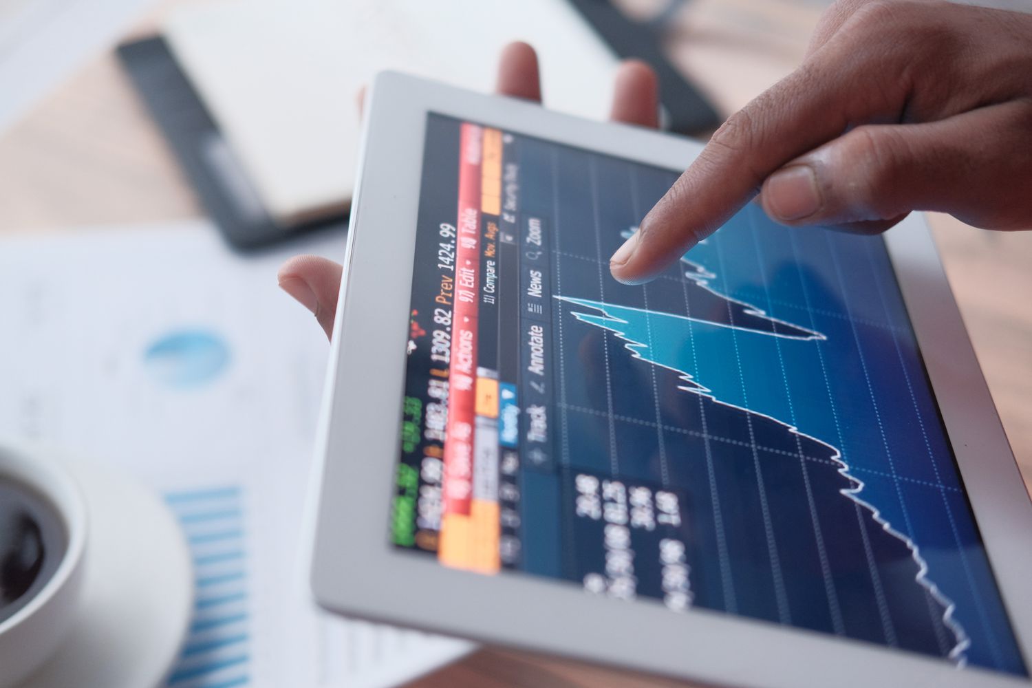 person looking at stock market on tablet