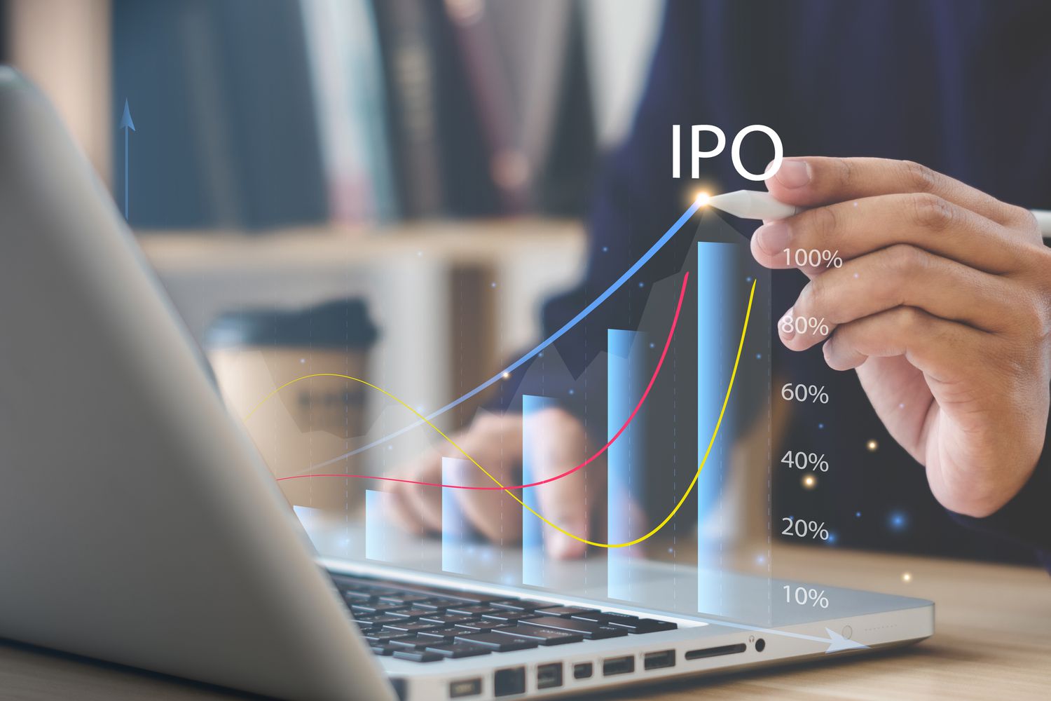 A close up of a laptop and a hand holding a pen pointing to a graphic of the rising price of an initial public offering.