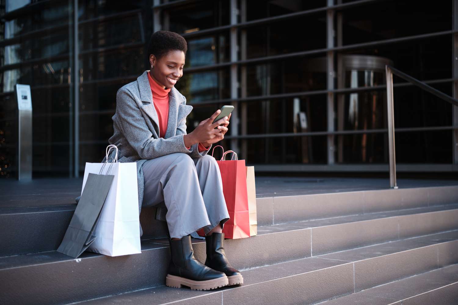 Young woman sitting so steps looking at her mobile device.