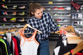 A woman shops in the athletic section. 