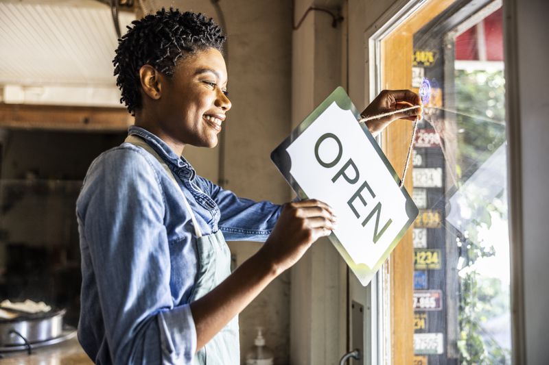Female business owner opening shop at the beginning of the day.