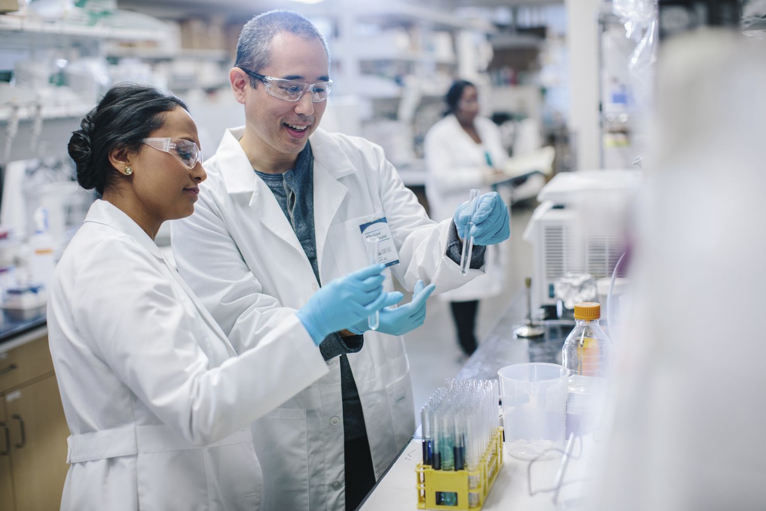 Two research and development chemist examine test results contained in test tubes in a research laboratory.