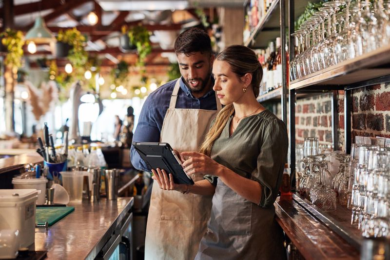 Two employees review information on a tablet.