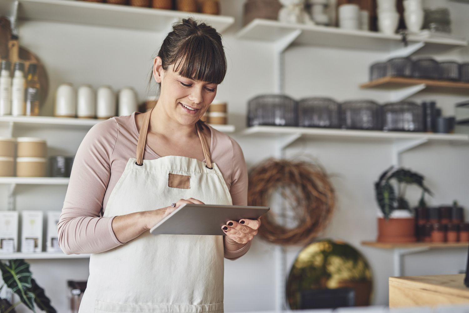 Young female florist using a digital tablet in her flower shop