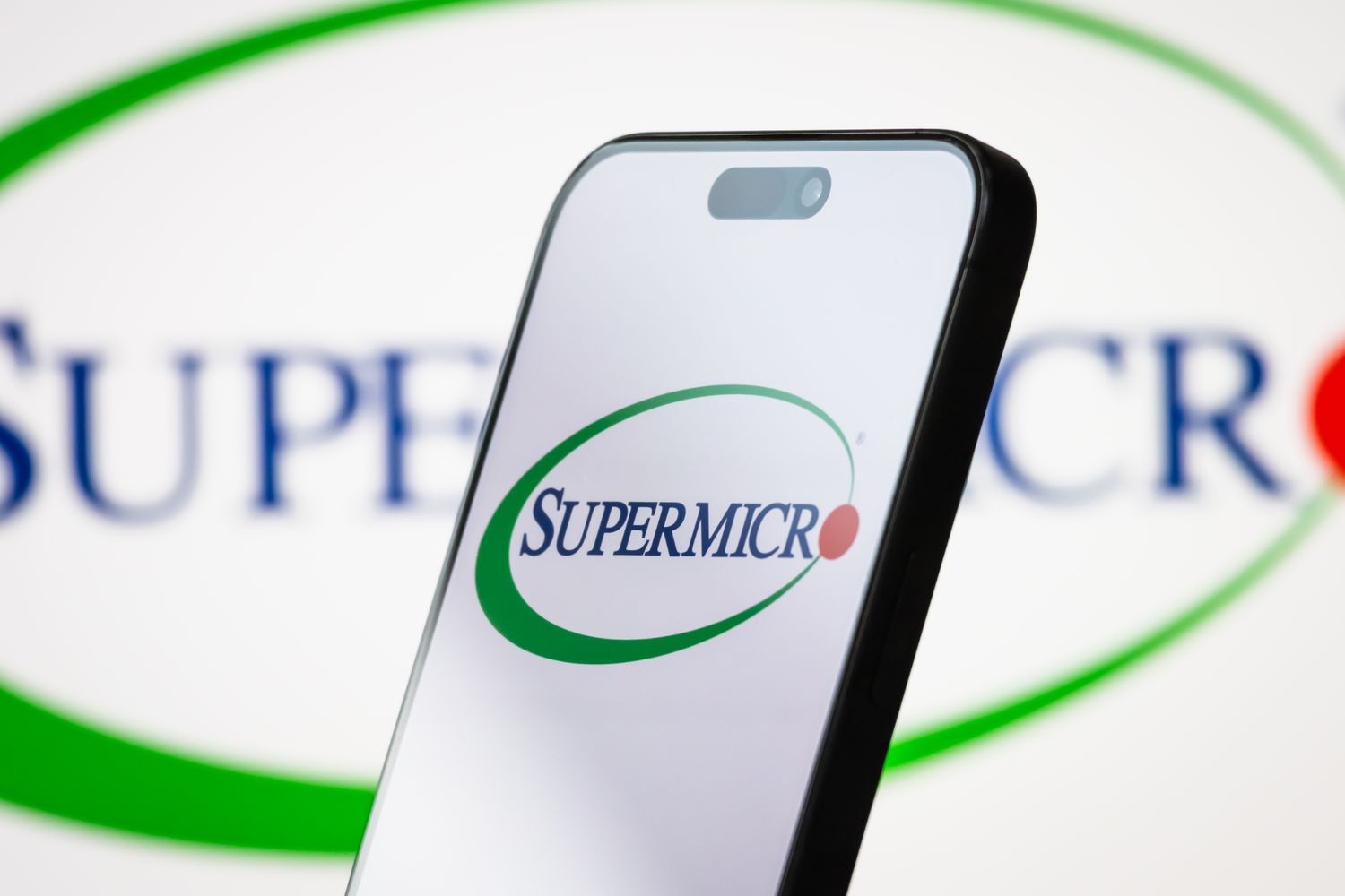 The logo of Super Micro Computer, Inc. (Supermicro) is displayed on a smartphone screen, with the company's branding visible in the background