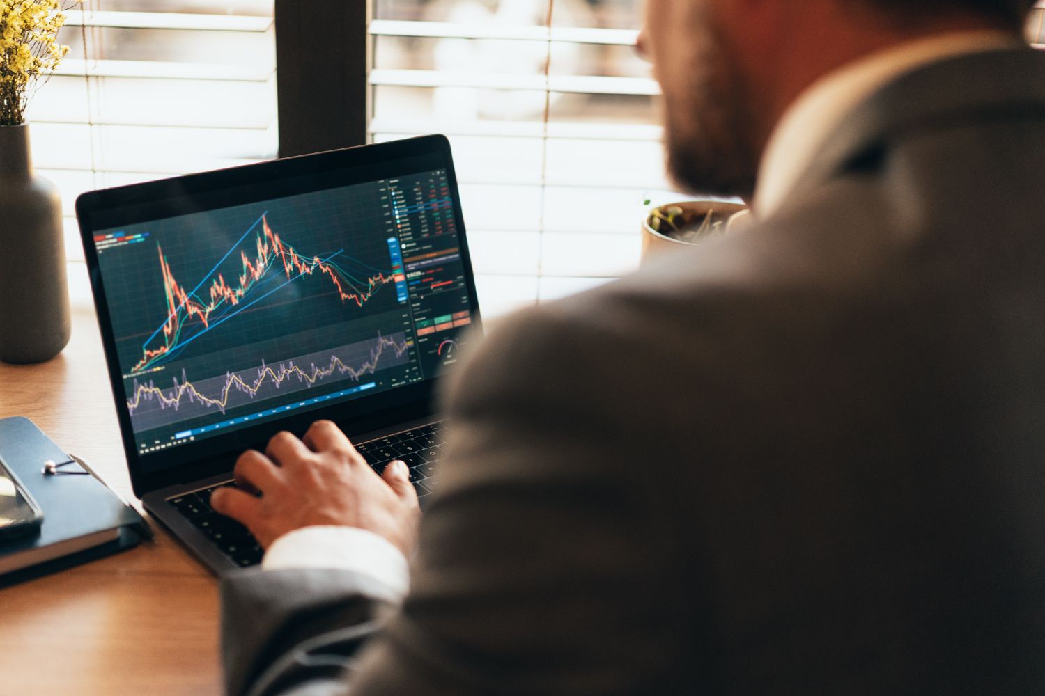A stock investor using a laptop to track a short position in an asset they are holding.
