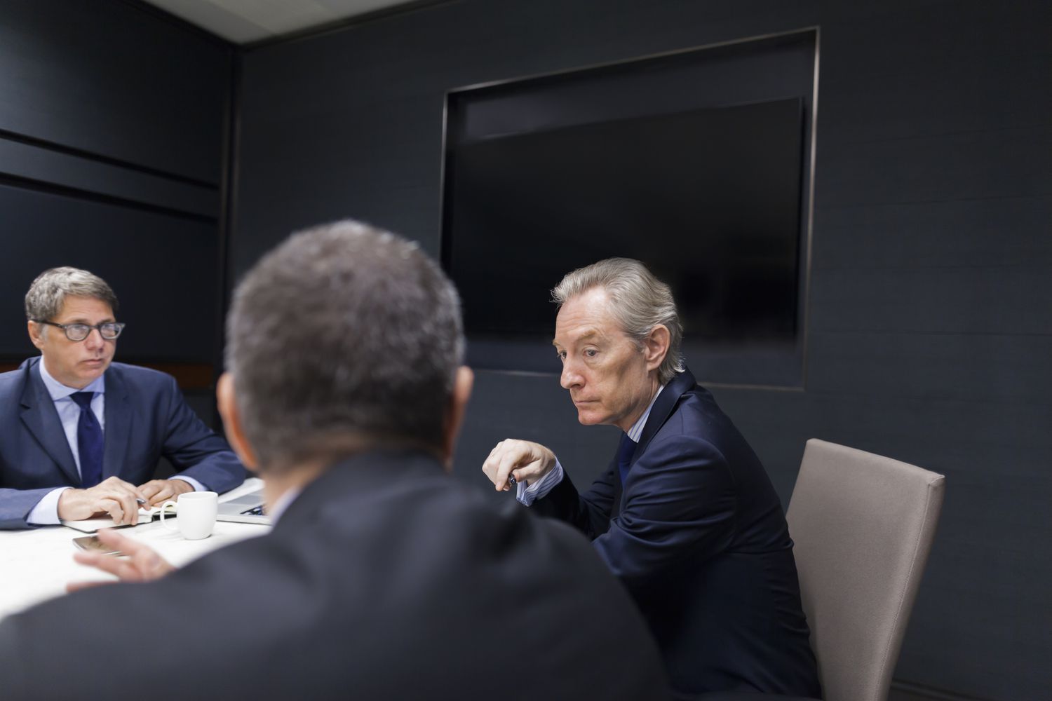 Board members sit around a conference table to discuss changes to the board that must be put to a shareholder vote.