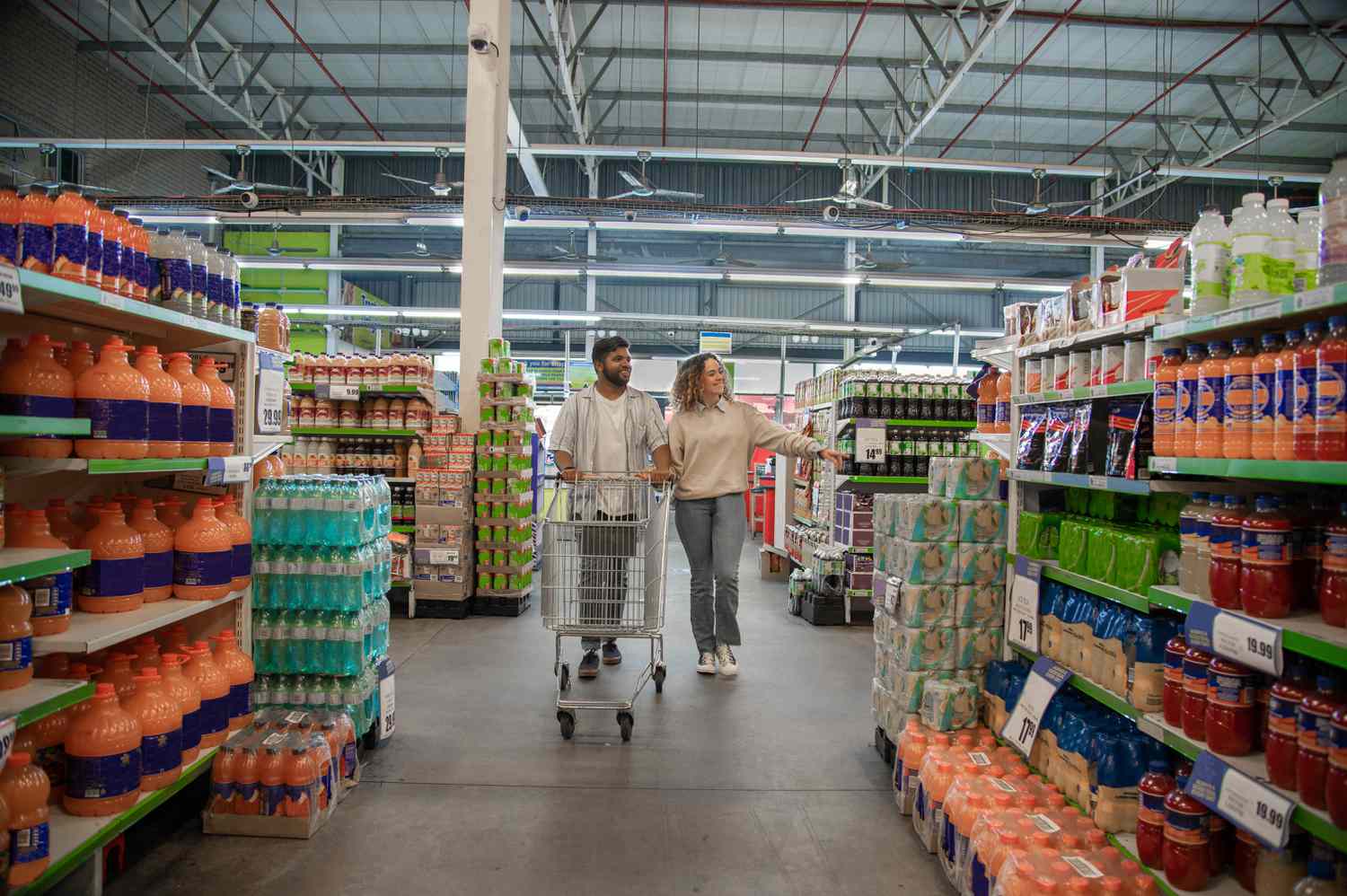 A couple walks through the grocery store. 