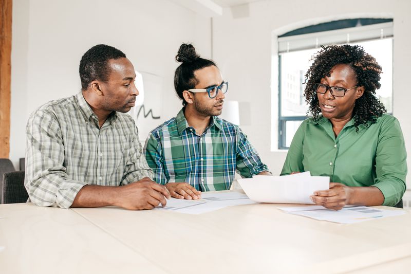 Financial advisor talking to two clients at a table