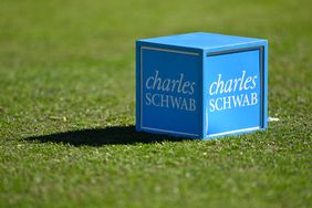 The Charles Schwab logo is seen on a blue tee box on a golf course.