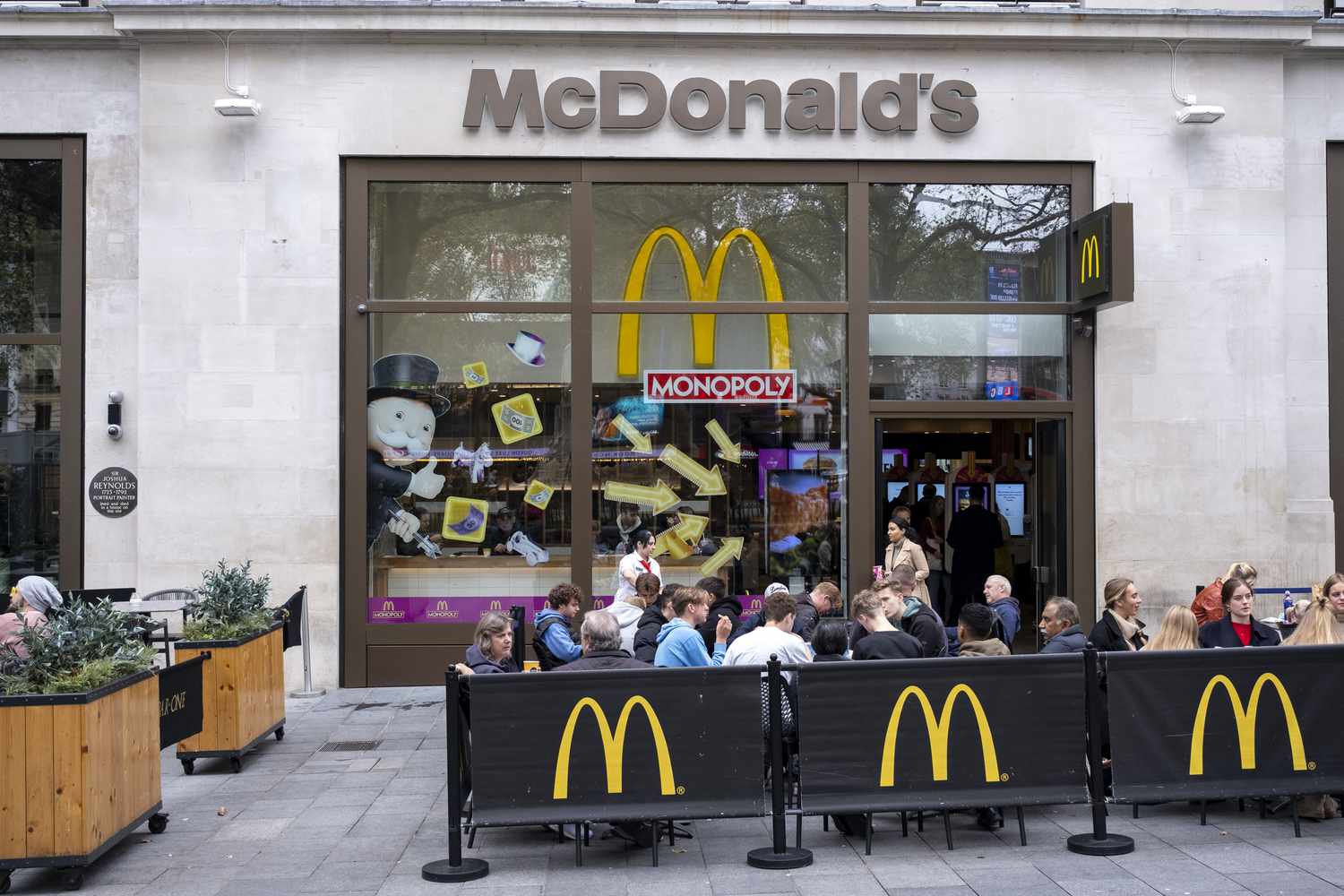 A group of customers sit outside a McDonald's restaurant in London