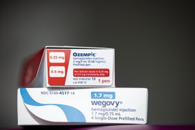 A red and white box of Ozempic is sitting on top of a white and blue box of Wegovy.