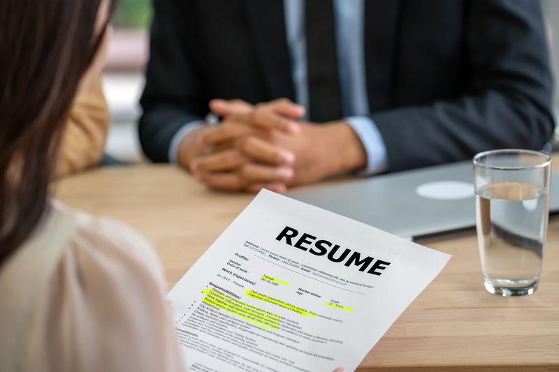 Employer reviews applicant's resume during job interview.