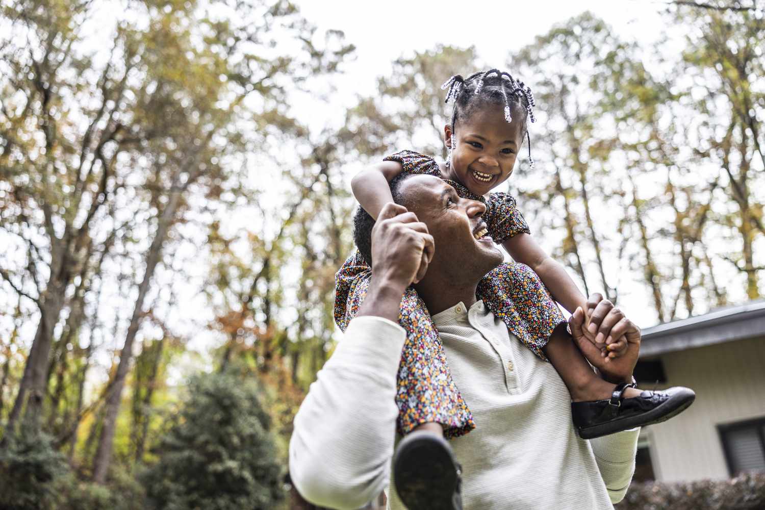 Father giving daughter a piggyback ride outside
