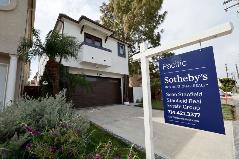 A home for sale sign in front of a house in Huntington Beach.