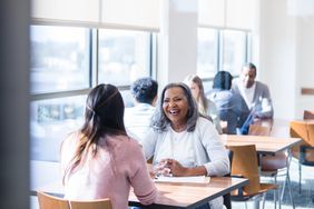 Senior woman smiles while meeting with financial advisor