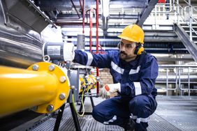 Refinery worker checking a pipeline for natural gas production