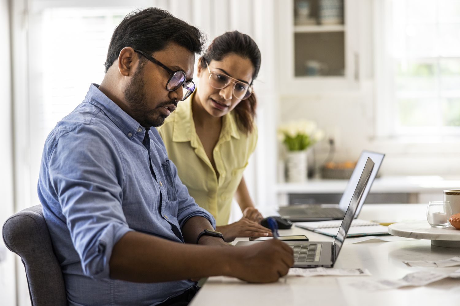 Man and woman in a kitchen with a laptop