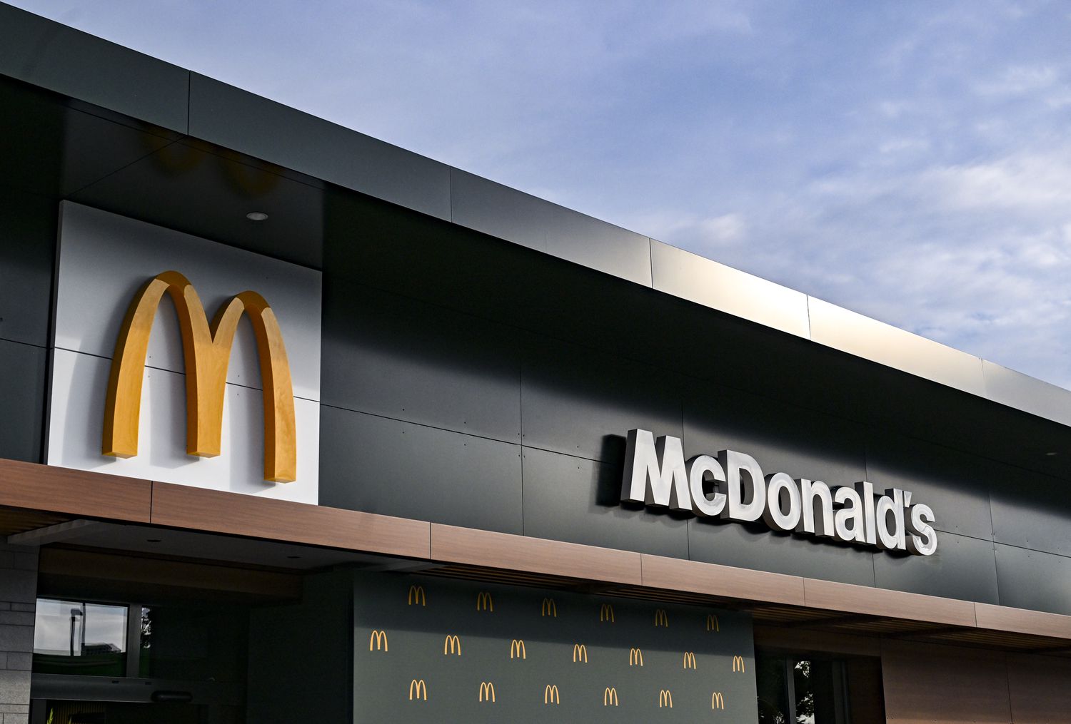 The McDonald's name and "golden arches" logo are seen on the side of a black building.
