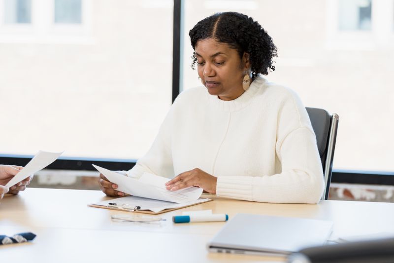 Woman sitting at a desk, studying documents