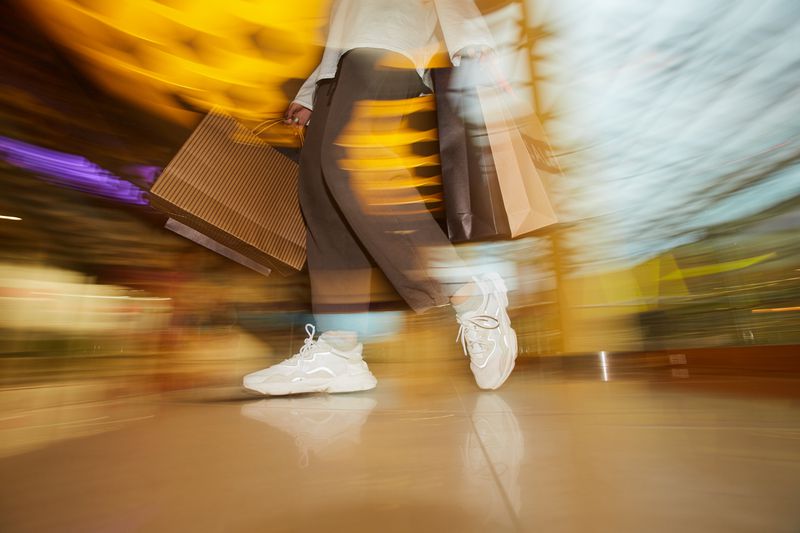 A blurred image of a shopper carrying bags. 