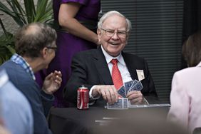 Warren Buffett, chairman of Berkshire Hathaway Inc., center, laughs with Bill Gates, chairman and founder of Microsoft Corp. and a Berkshire Hathaway Inc. director, left, as they play bridge during a shareholder event on the sidelines of the Berkshire Hathaway Inc. annual shareholders meeting in Omaha, Nebraska, U.S., on Sunday, May 3, 2015. 