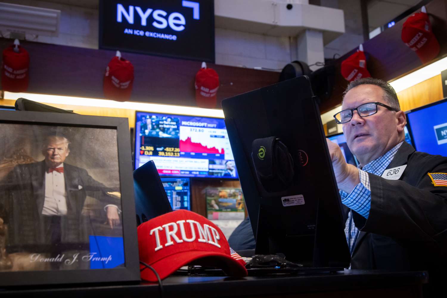 A photo of US President Donald Trump as a trader works on the floor of the New York Stock Exchange 