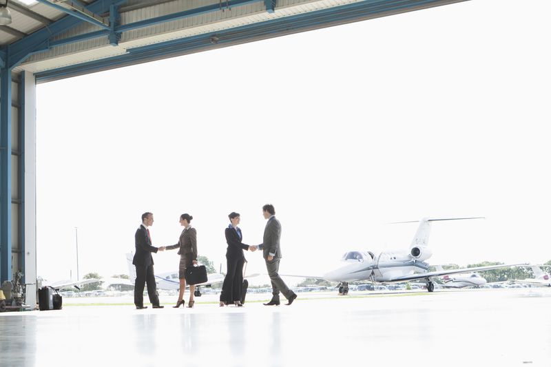Businessmen at airport shaking hands.