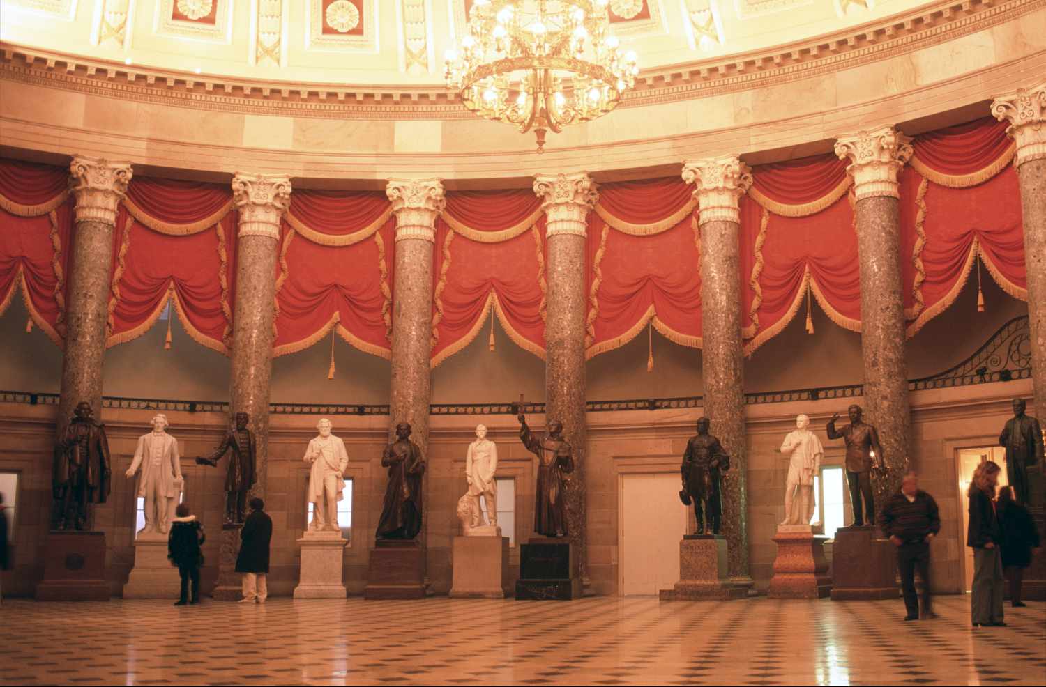 People wander around and look at statues in the Old Hall of Representatives in the U.S. Capitol building in Washington, D.C.
