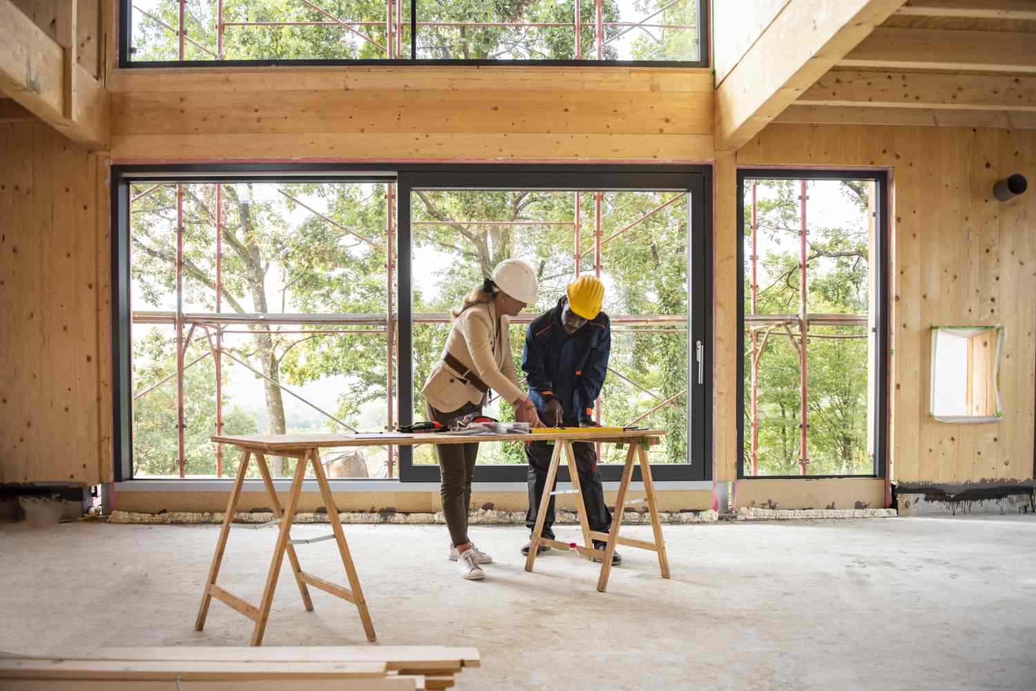 Homeowner and architect working on the floor plan of the house being constructed and financed by construction mortgage.