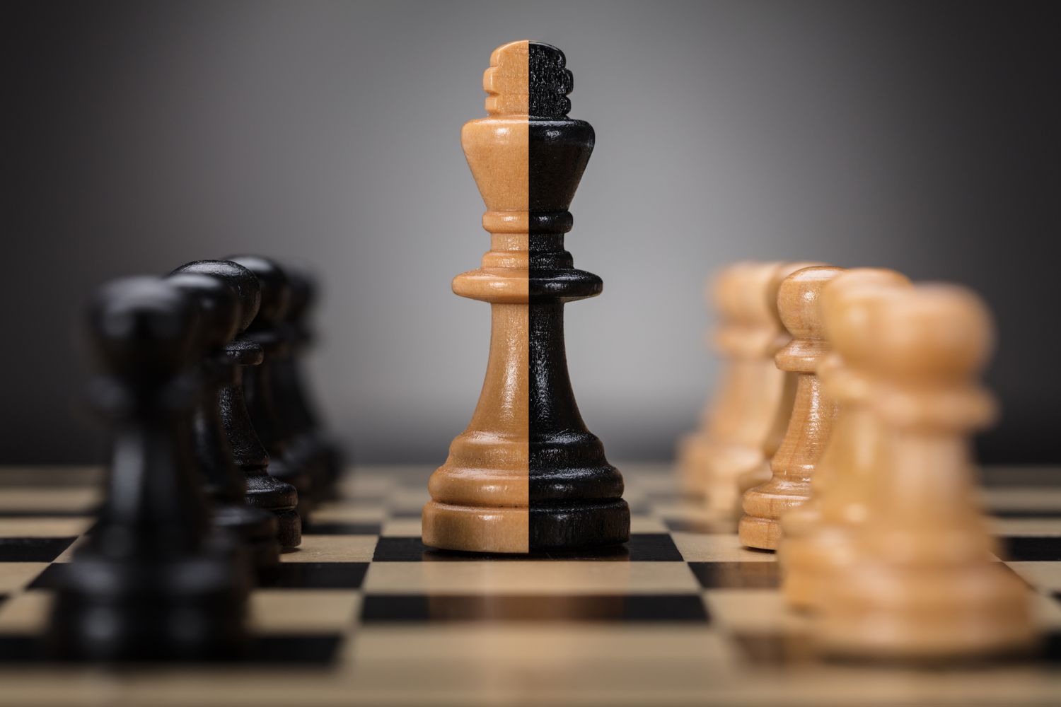 Black and brown colored king and pawns on chess board.