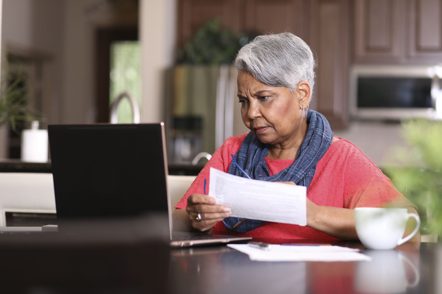 A woman reviews documents at a table.