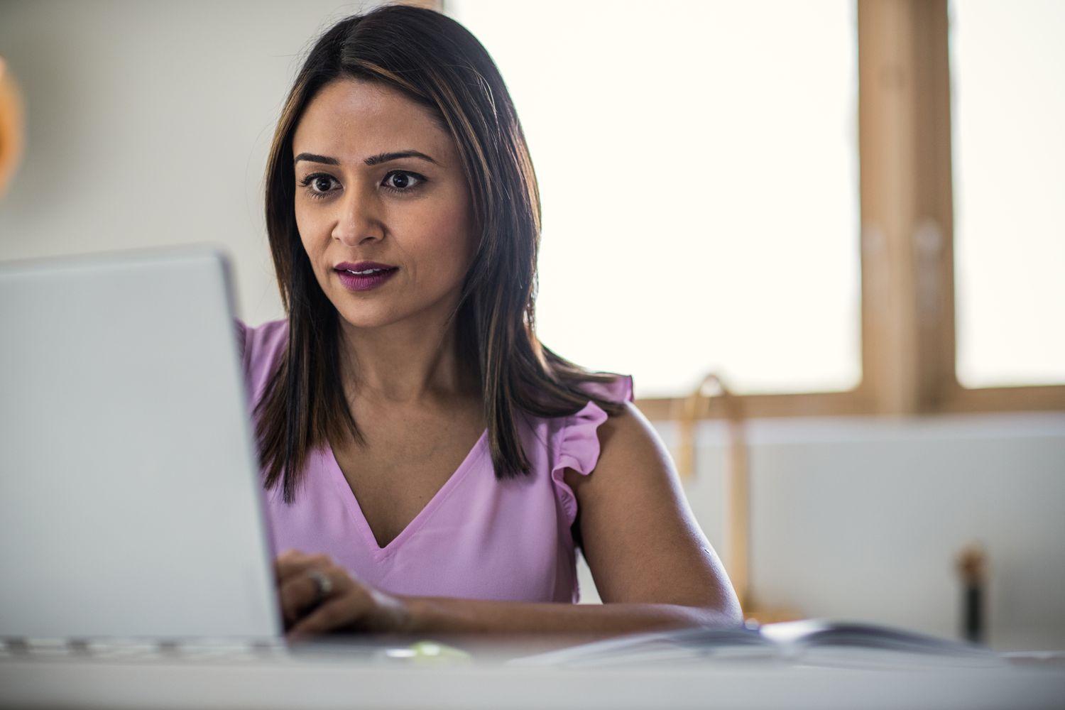Woman using her computer in her home to research the best secured loans