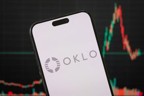 The gray Oklo logo is seen on a phone screen in front of a stock chart in the background.